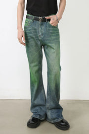 Acid wash flare denim jeans in medium with a green gradient effect, styled with a black belt and platform shoes.