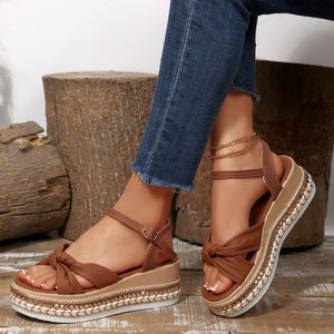 Brown bow knot wedge sandals with ankle buckle and braided trim detail.