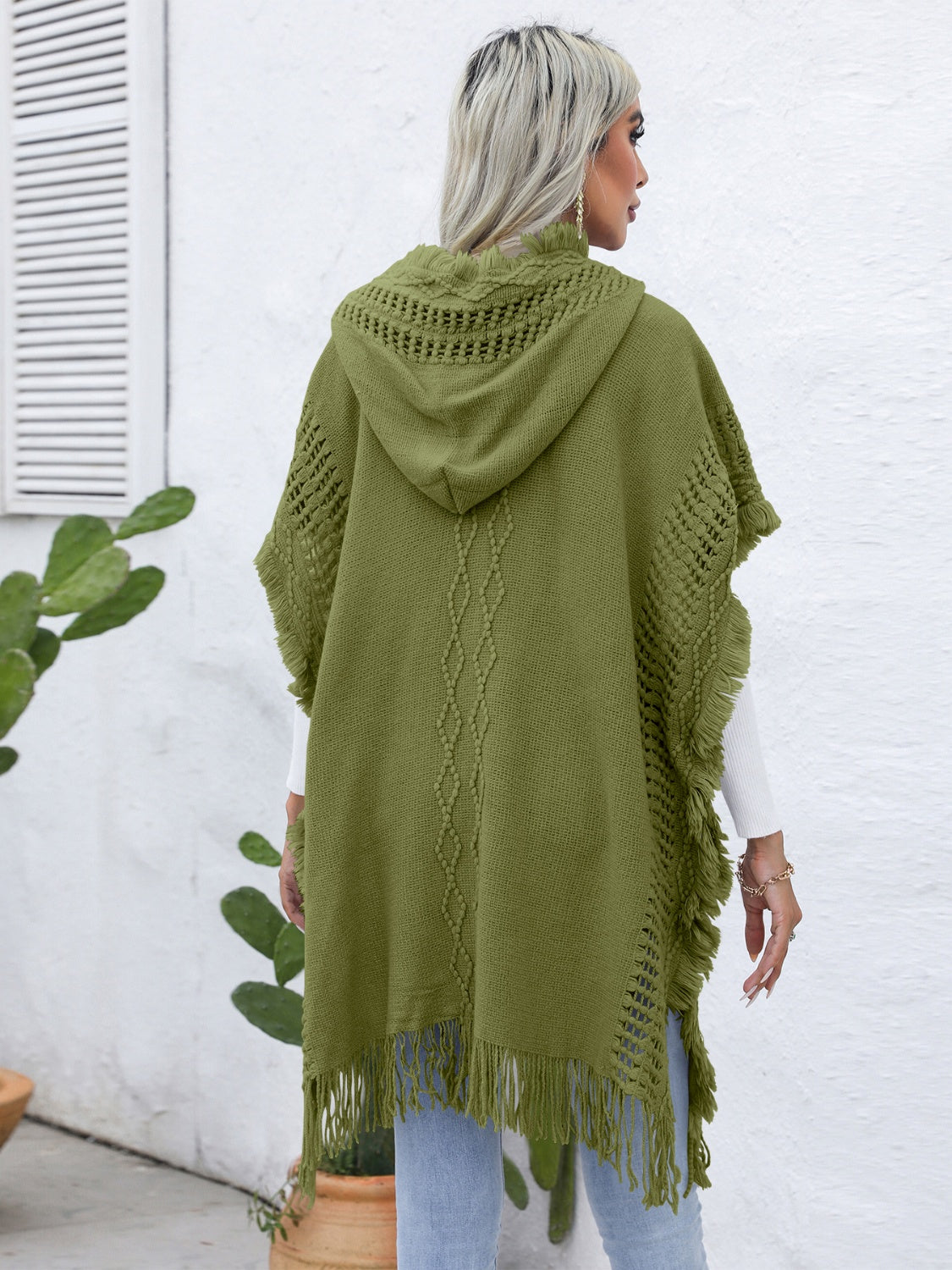 Matcha green knit poncho with fringe, hood, and diamond texture detail.