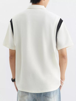 Men's beige cotton polo shirt with contrast black shoulder panels and textured fabric.
