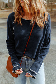 Navy waffle knit raglan sweater with ruffled cuffs and contrast trim.