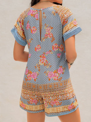 Light blue floral embroidered romper with short sleeves and cutout back detail.
