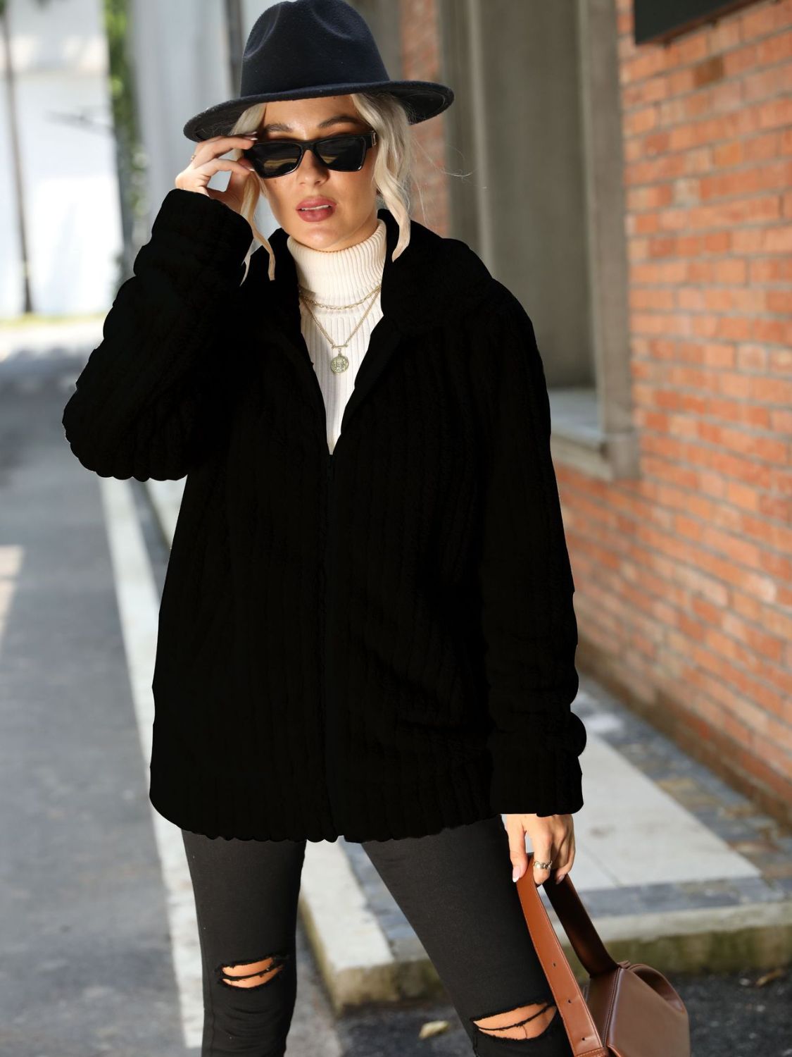 Black plush ribbed zip-up jacket with collared neckline.
