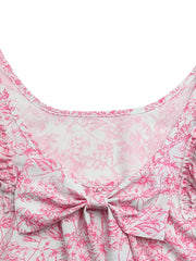 Maternity shirt with pink floral print, bow detail, and ruffle sleeves.