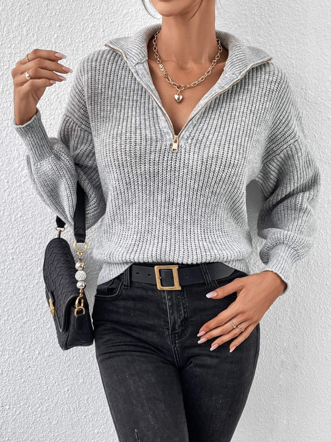 Gray ribbed collar zip-up knit sweater with gold zipper detail.