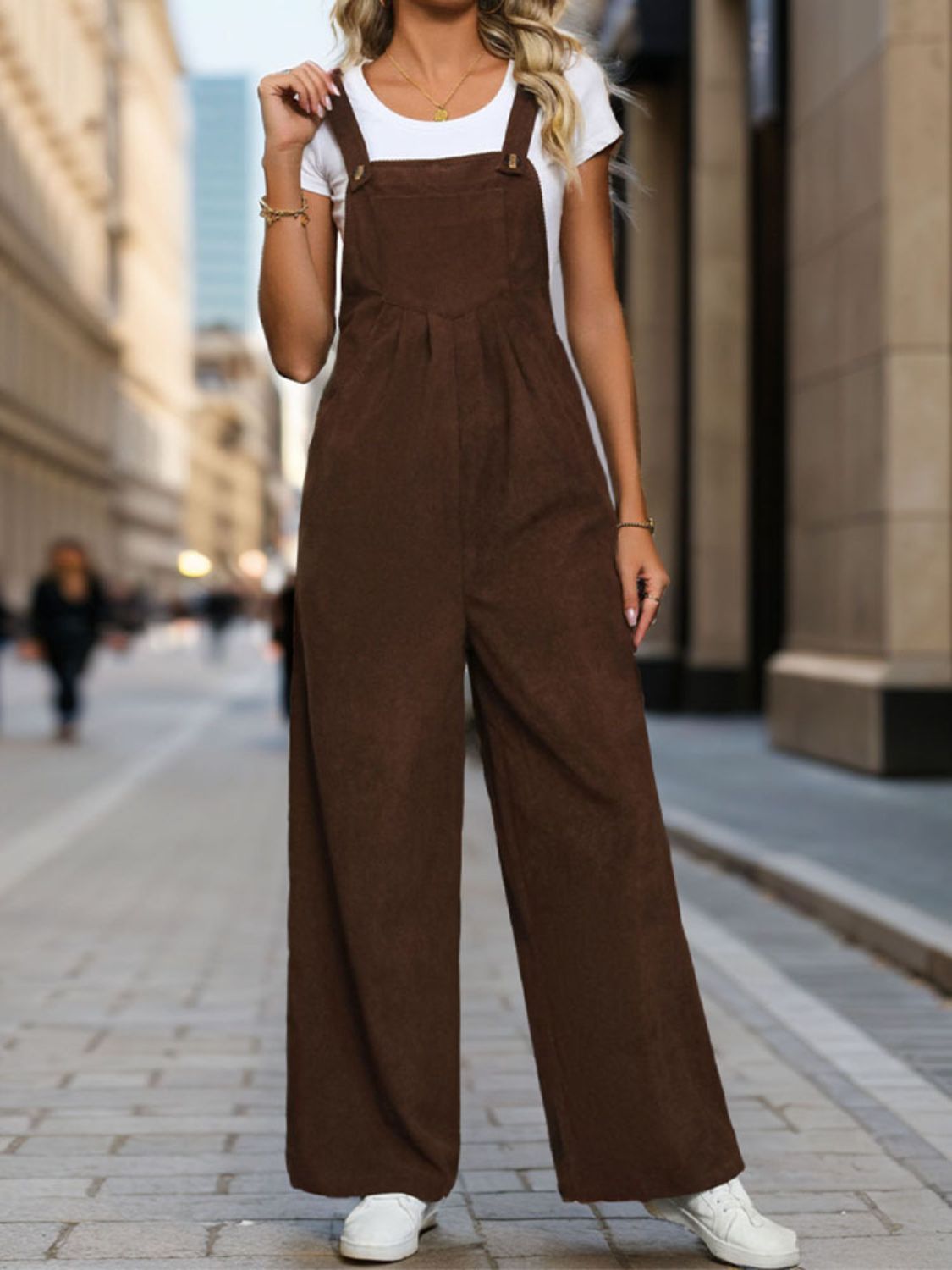 Brown corduroy wide-leg suspender jumpsuit with button details.