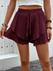 Burgundy tiered gauze drawstring shorts with ruffled hem detail.