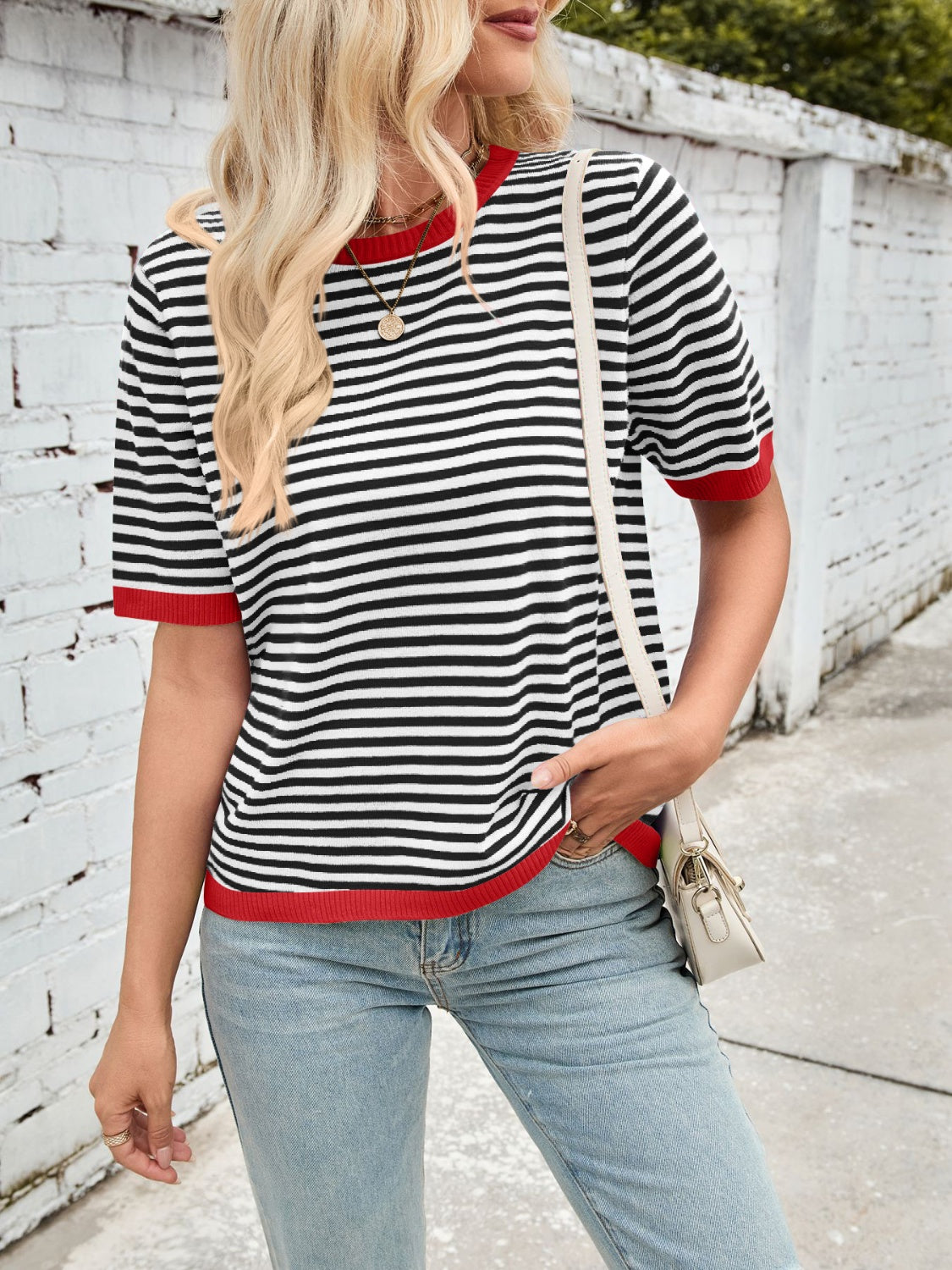 Striped knit tee with red trim and crew neck, styled with light wash jeans.