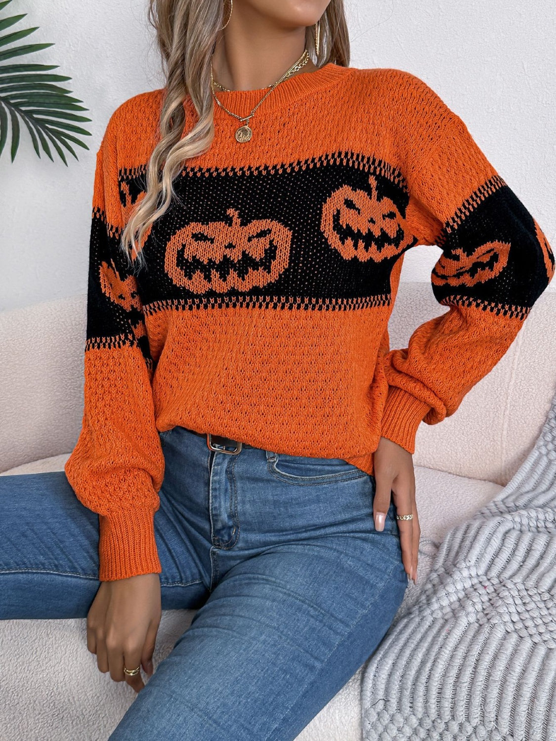 Orange acrylic knit sweater with black jack-o'-lantern intarsia pattern and crew neck.