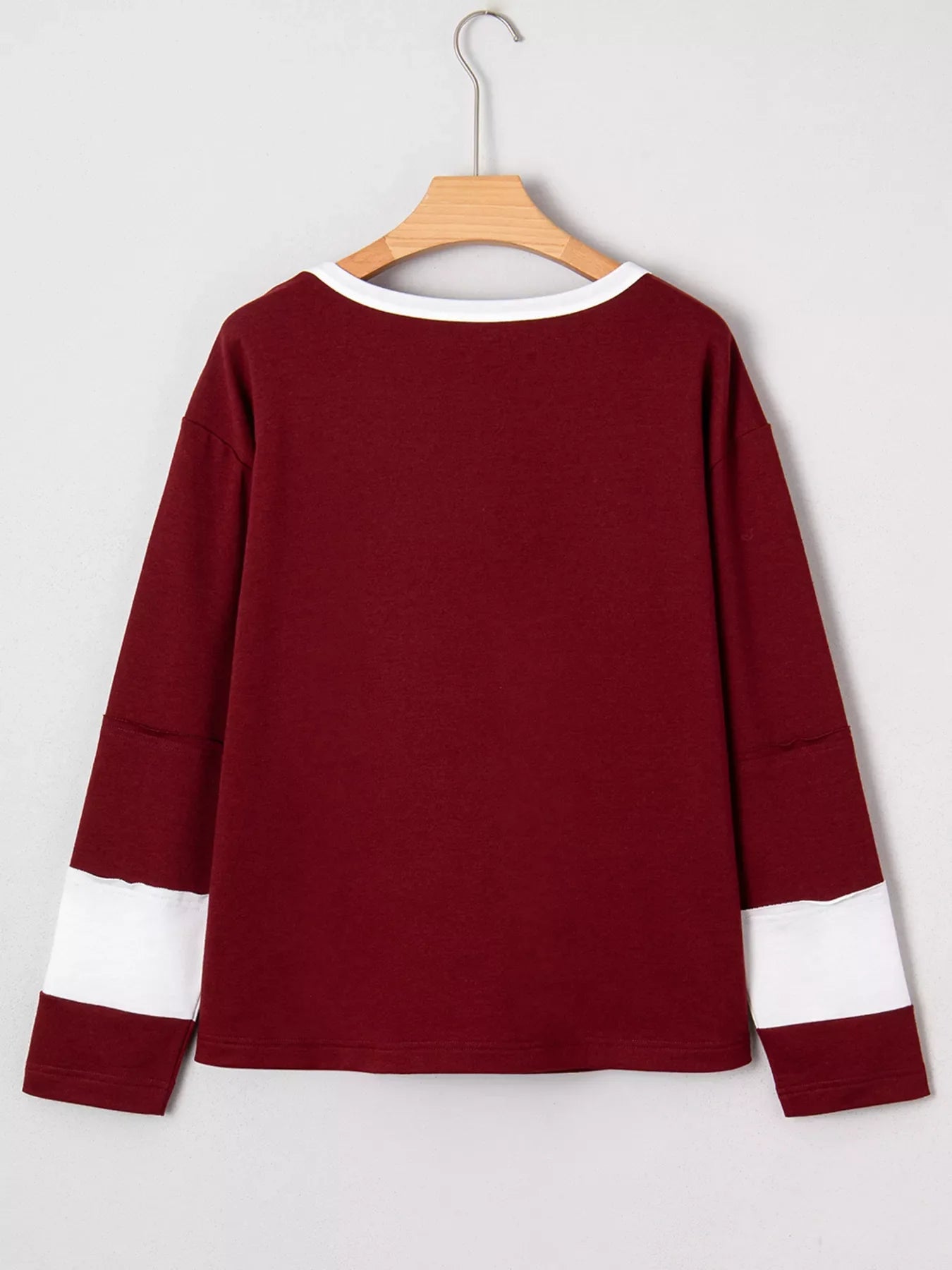 Burgundy long sleeve top with white trim and sleeve details