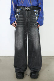 Dark wash denim jeans with painterly splatters and a wide flare leg.