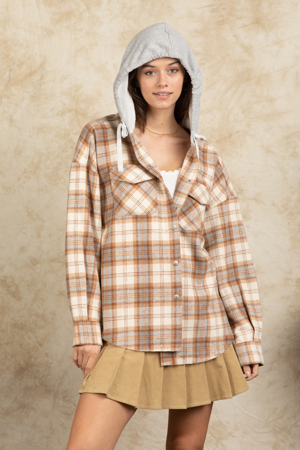 Cozy plaid shacket with sherpa hood in Camel, featuring button front and chest pockets.
