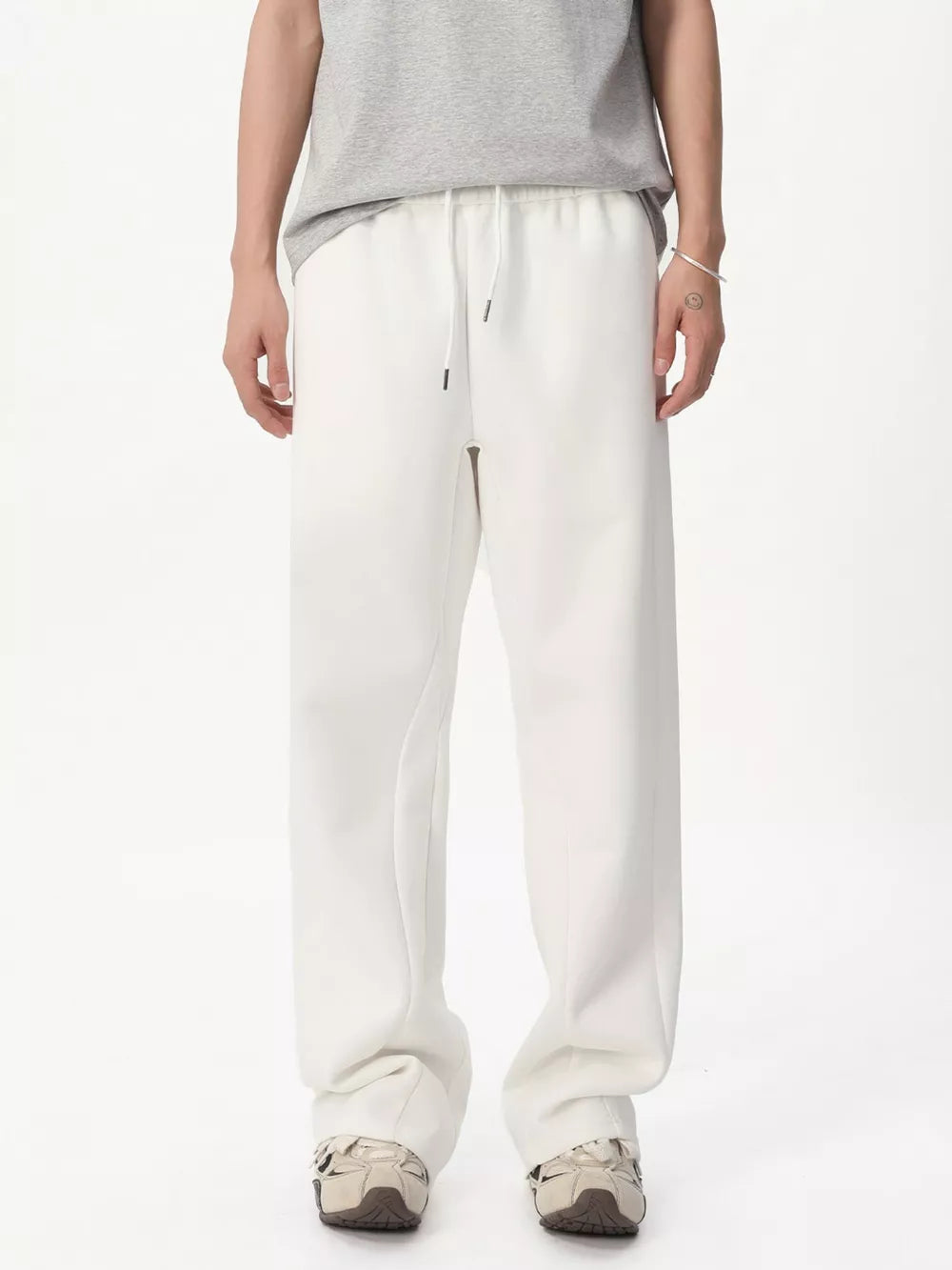 White relaxed fit sweatpants with adjustable drawstring waist and pockets.