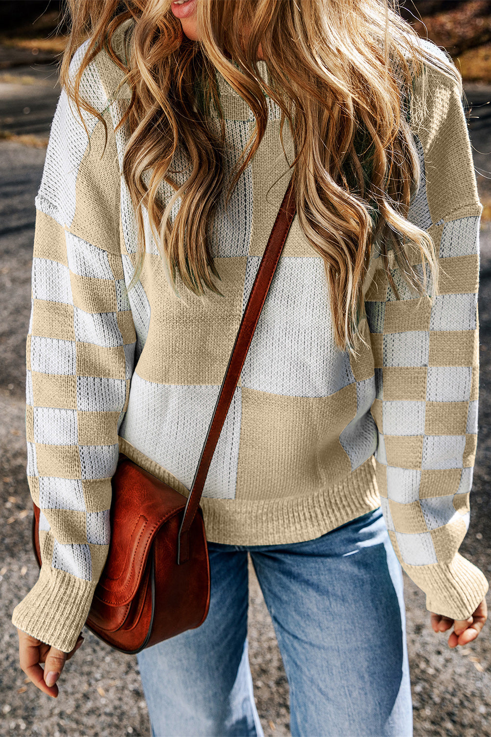 Beige and white checkerboard knit sweater with crew neck and long sleeves.