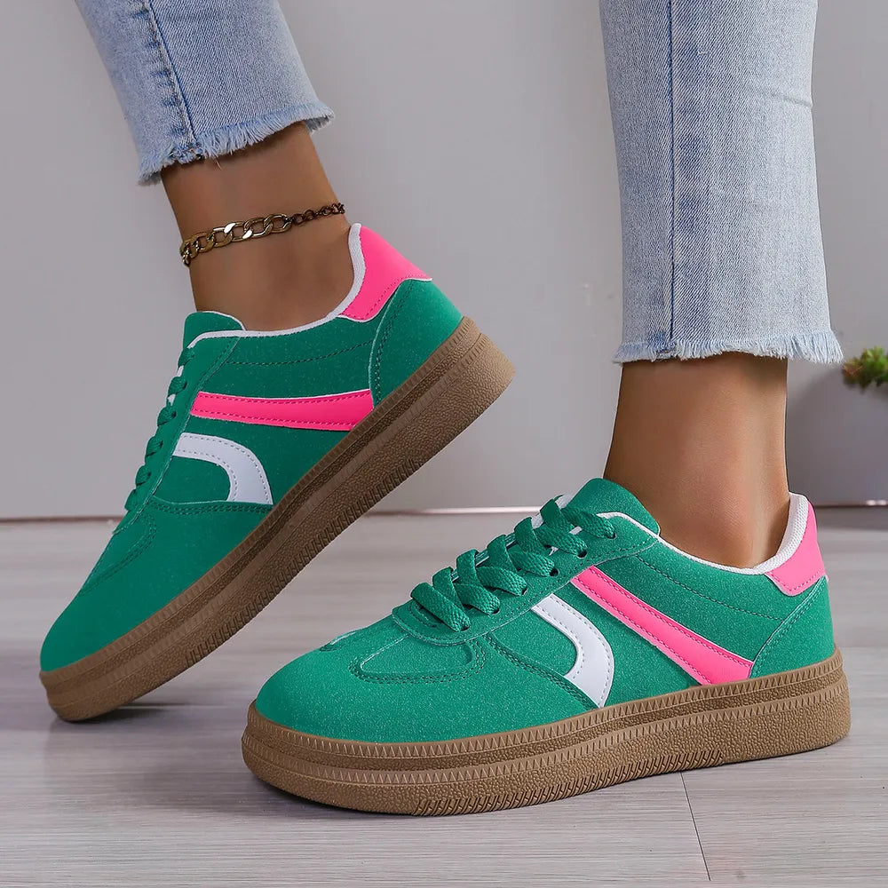 Green suede platform sneakers with pink and white curved stripes and gum soles.