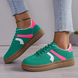 Green suede platform sneakers with pink and white curved stripes and gum soles.