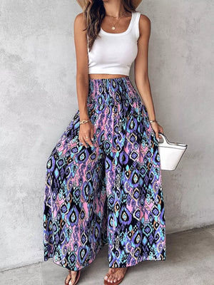 Bohemian print wide leg pants with smocked waist in purple, pink, blue, and black pattern.
