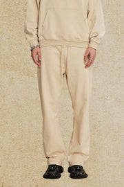 Relaxed fit tan joggers with drawstring waist and cuffed ankles.