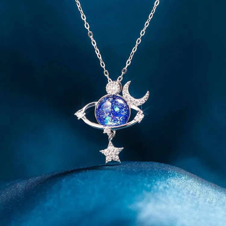 Silver celestial necklace with cosmic orb, moon, and star charms.