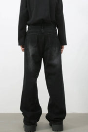 Faded black baggy denim trousers with a relaxed fit and distressed details.