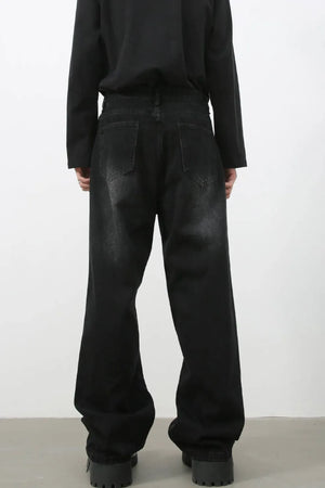 Faded black baggy denim trousers with a relaxed fit and distressed details.