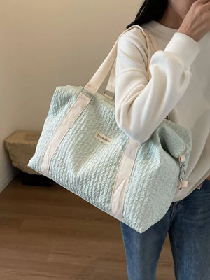 Light blue textured travel bag with cream straps and detachable pouch