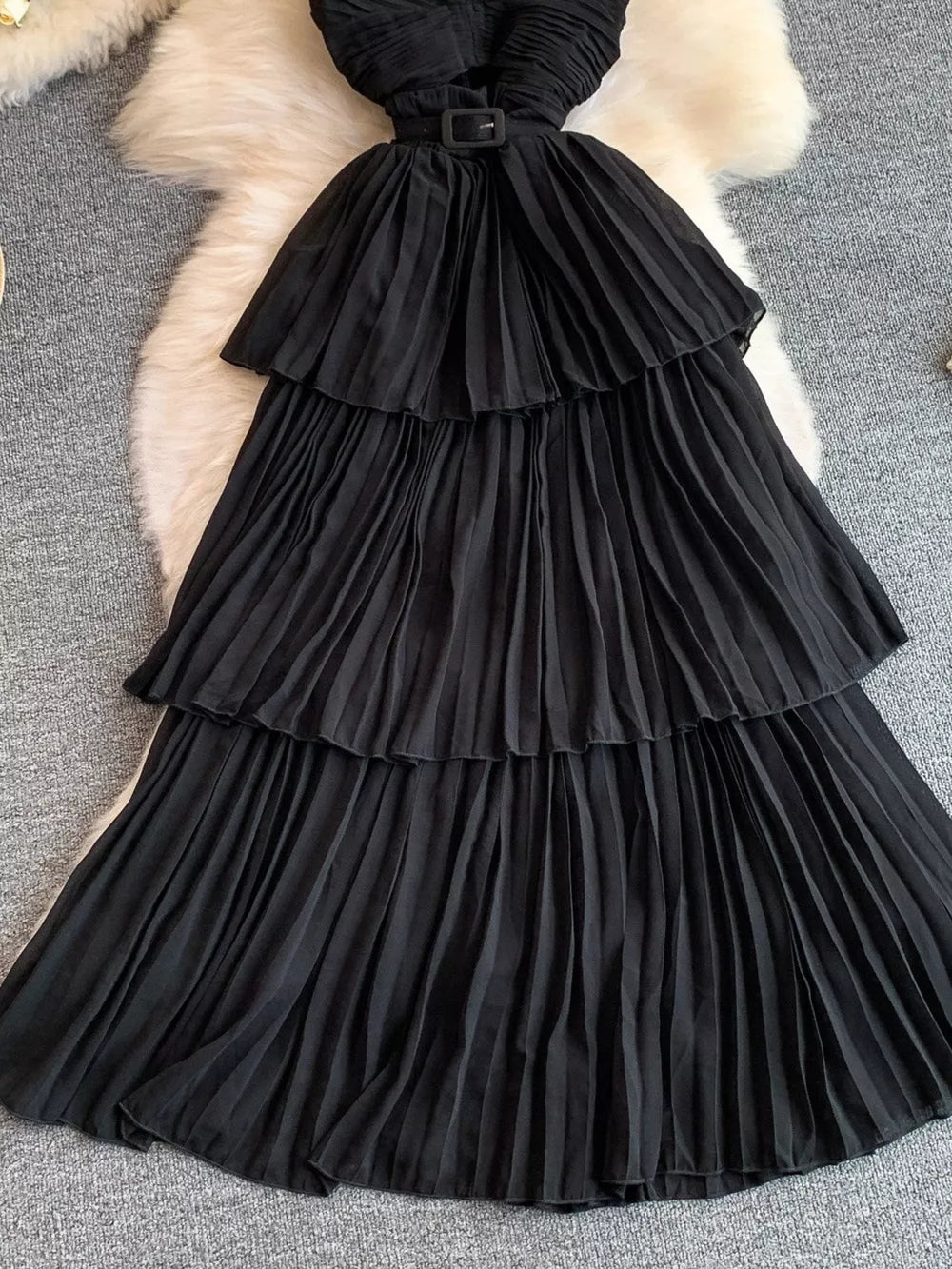 Black pleated midi dress with tiered skirt and belted waist