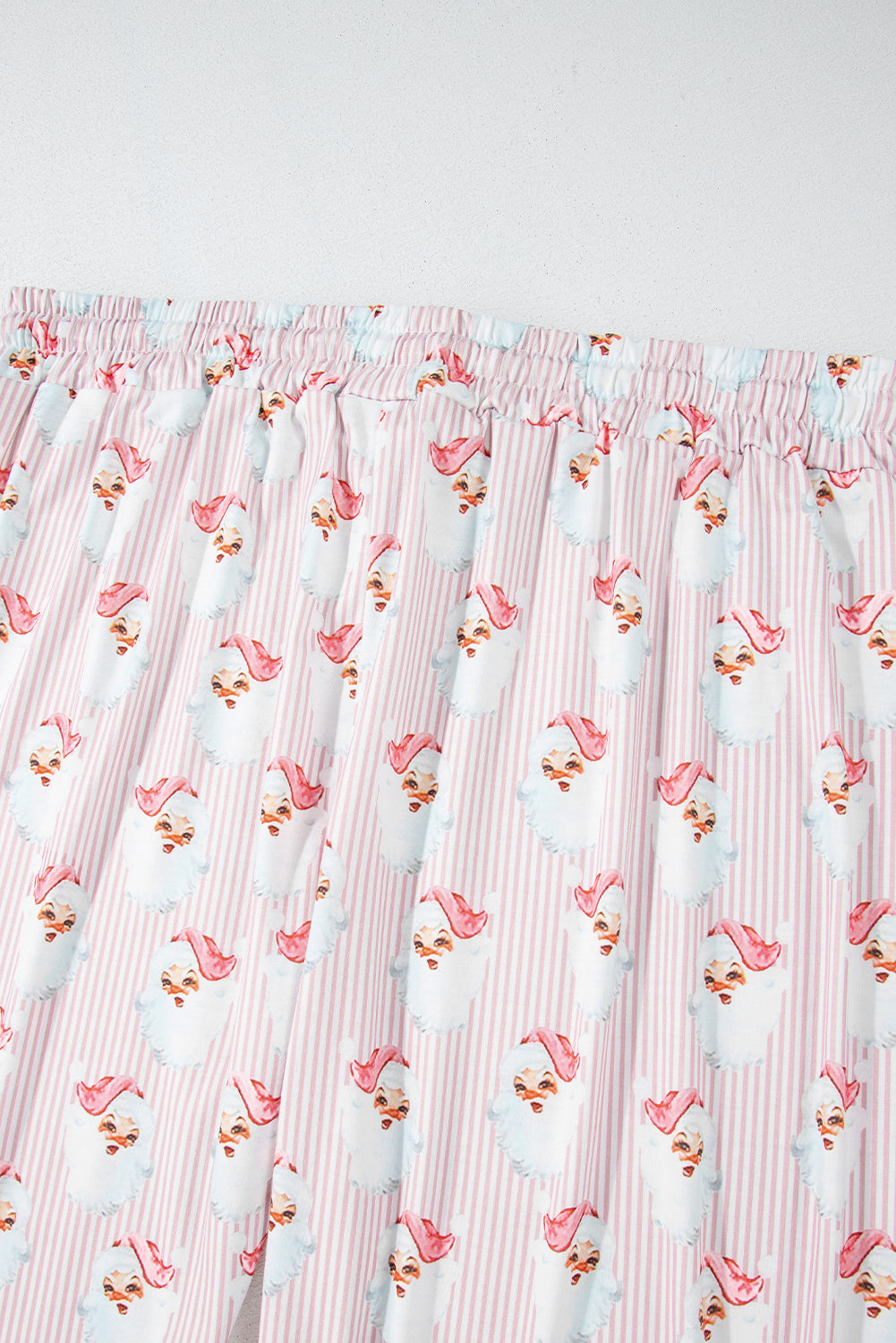 Santa stripe lounge set in blush pink with a playful Santa Claus print and pinstripe pattern.