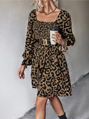 Smocked bodice leopard print mini dress with square neckline and long sleeves.