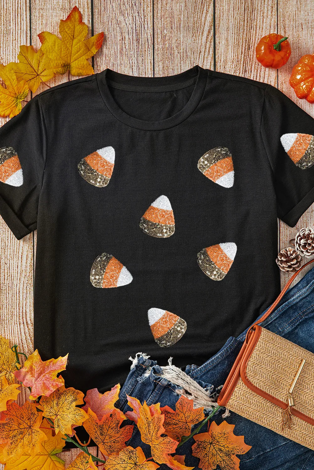 Black t-shirt with scattered sequined candy corn pattern.