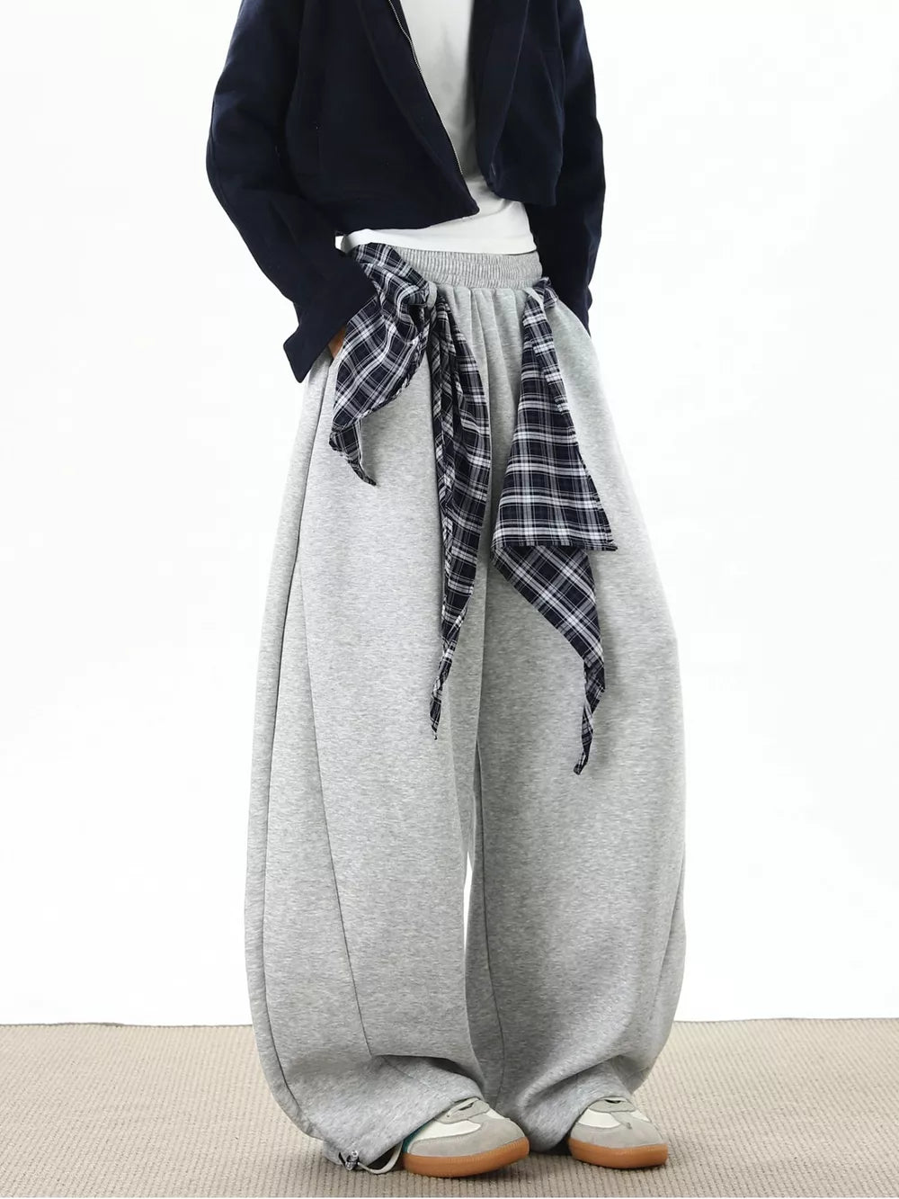 Grey relaxed fit wide-leg sweatpants with plaid tie detail and cuffed ankles.