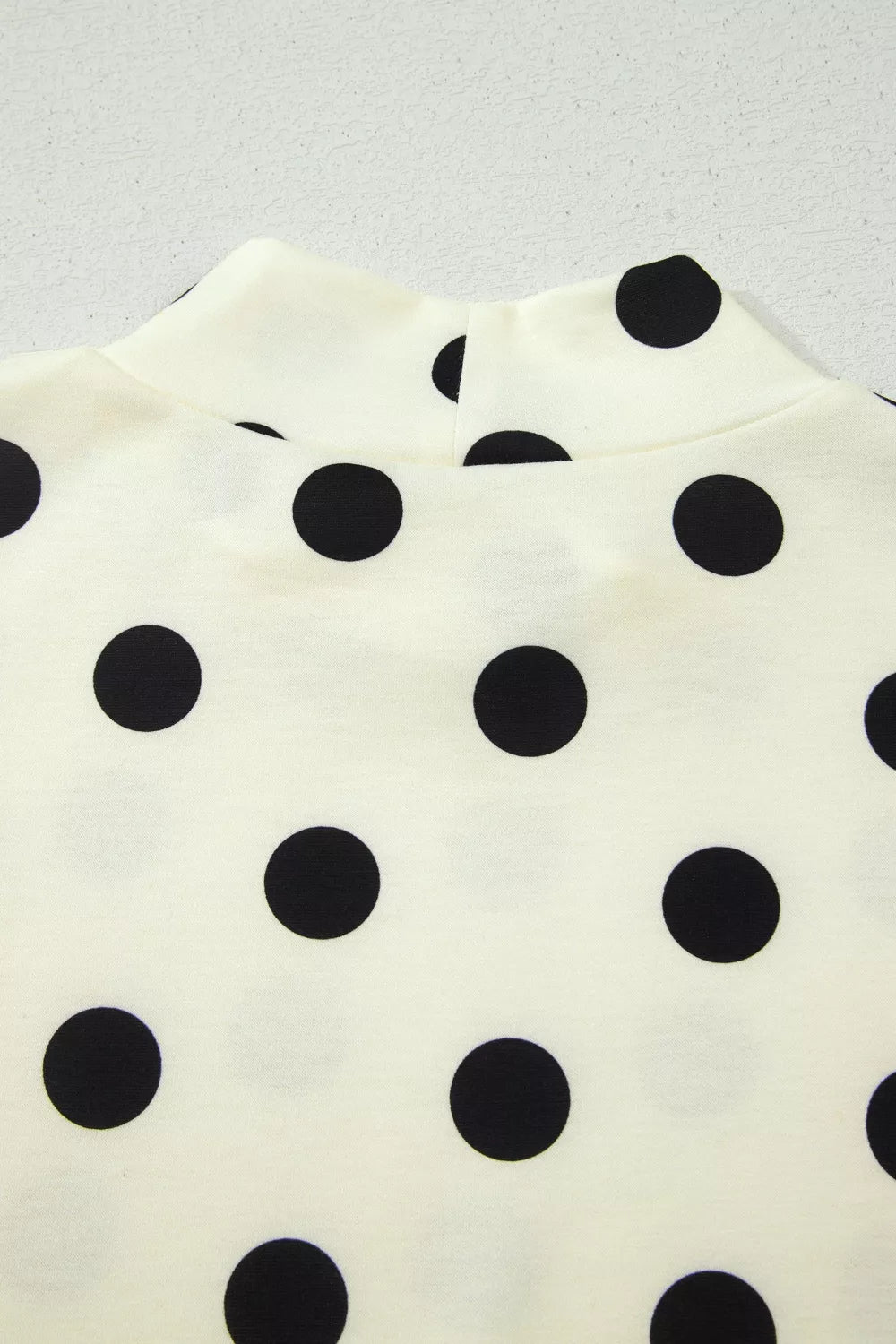 Cream polyester t-shirt with black polka dots and high neckline