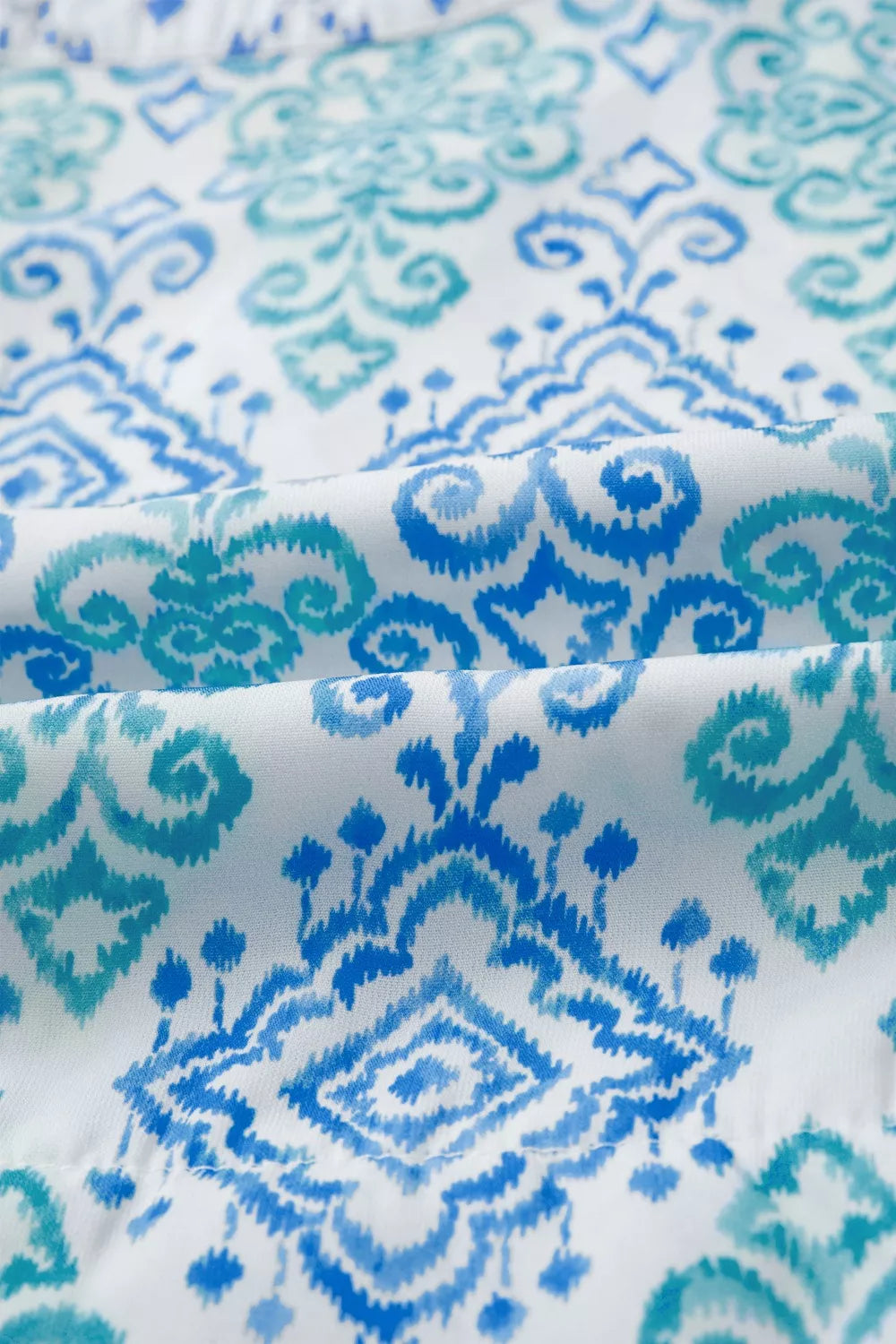 Patchwork babydoll shirt in white with blue and teal ikat print, polyester