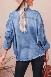 Light wash denim oversized shirt with raw hemline and distressed details.