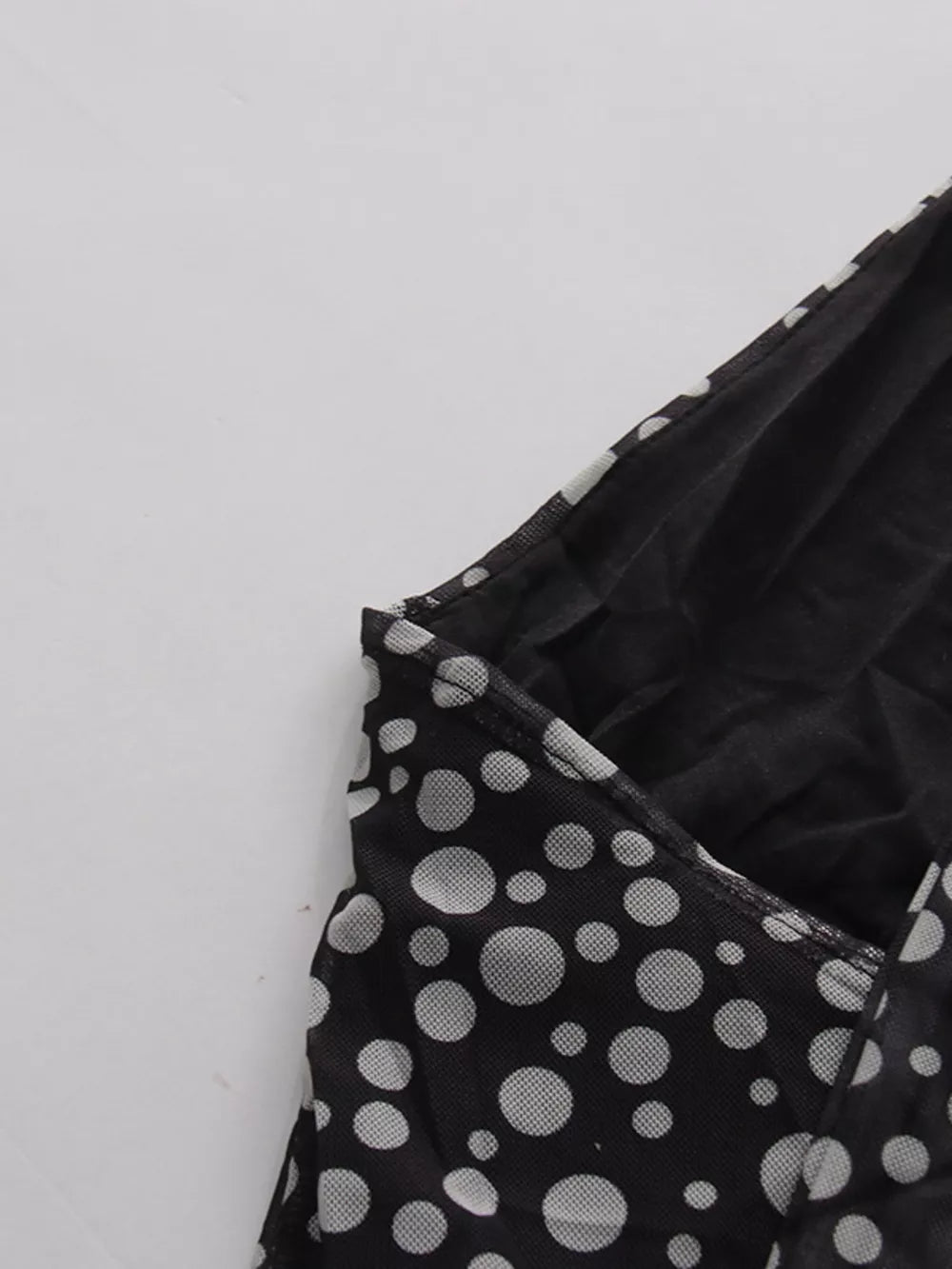 Black polka dot halter maxi dress detail showing mesh fabric and neckline.