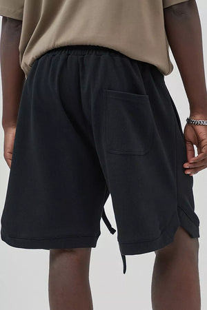 Black drawstring boxer shorts with a back pocket and textured fabric.
