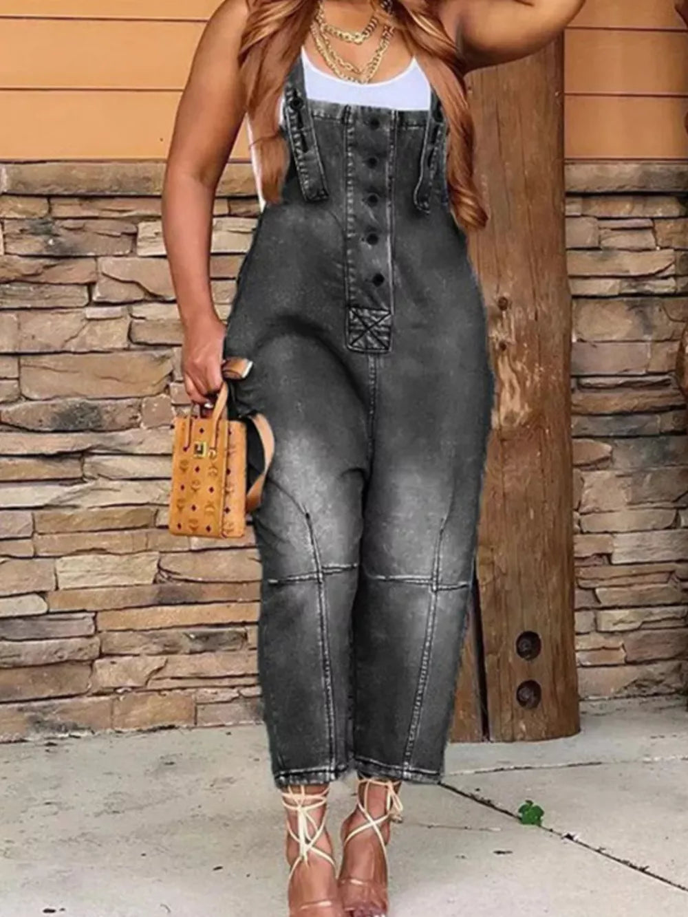 Black denim overalls with button-front, adjustable straps, and cropped legs.