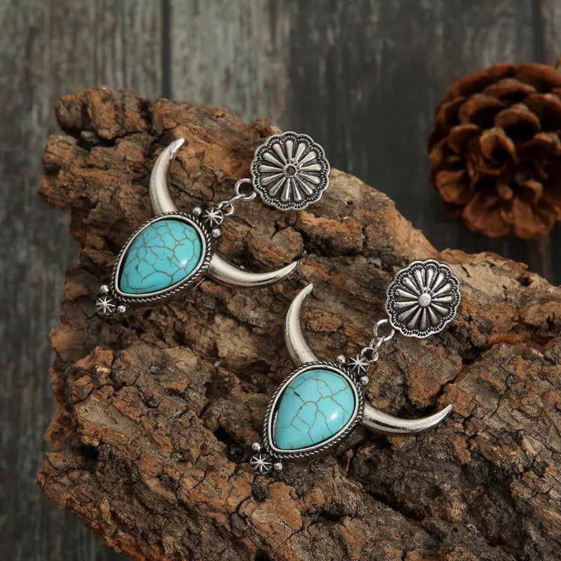 Southwestern crescent drop earrings with turquoise stones and silver alloy.