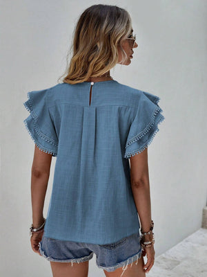 Dusty Blue ruffle sleeve blouse with pom-pom trim and keyhole back detail.