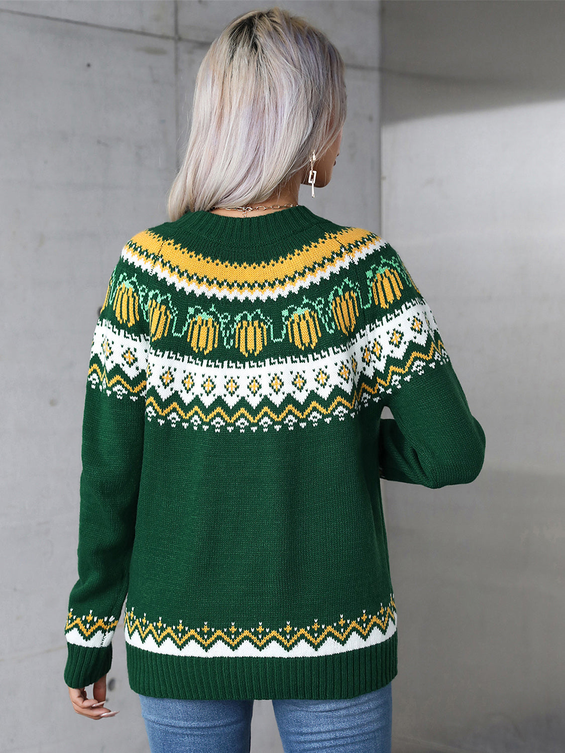 Autumnal Fair Isle crewneck knit sweater in dark green with yellow and white pumpkin pattern.