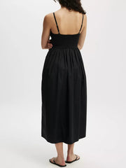 Black midi dress with adjustable straps, defined waist, and full skirt with pockets.