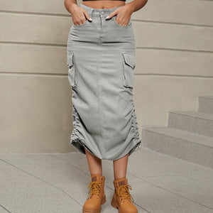 Mid gray denim midi cargo skirt with adjustable ruching detail and front pockets.