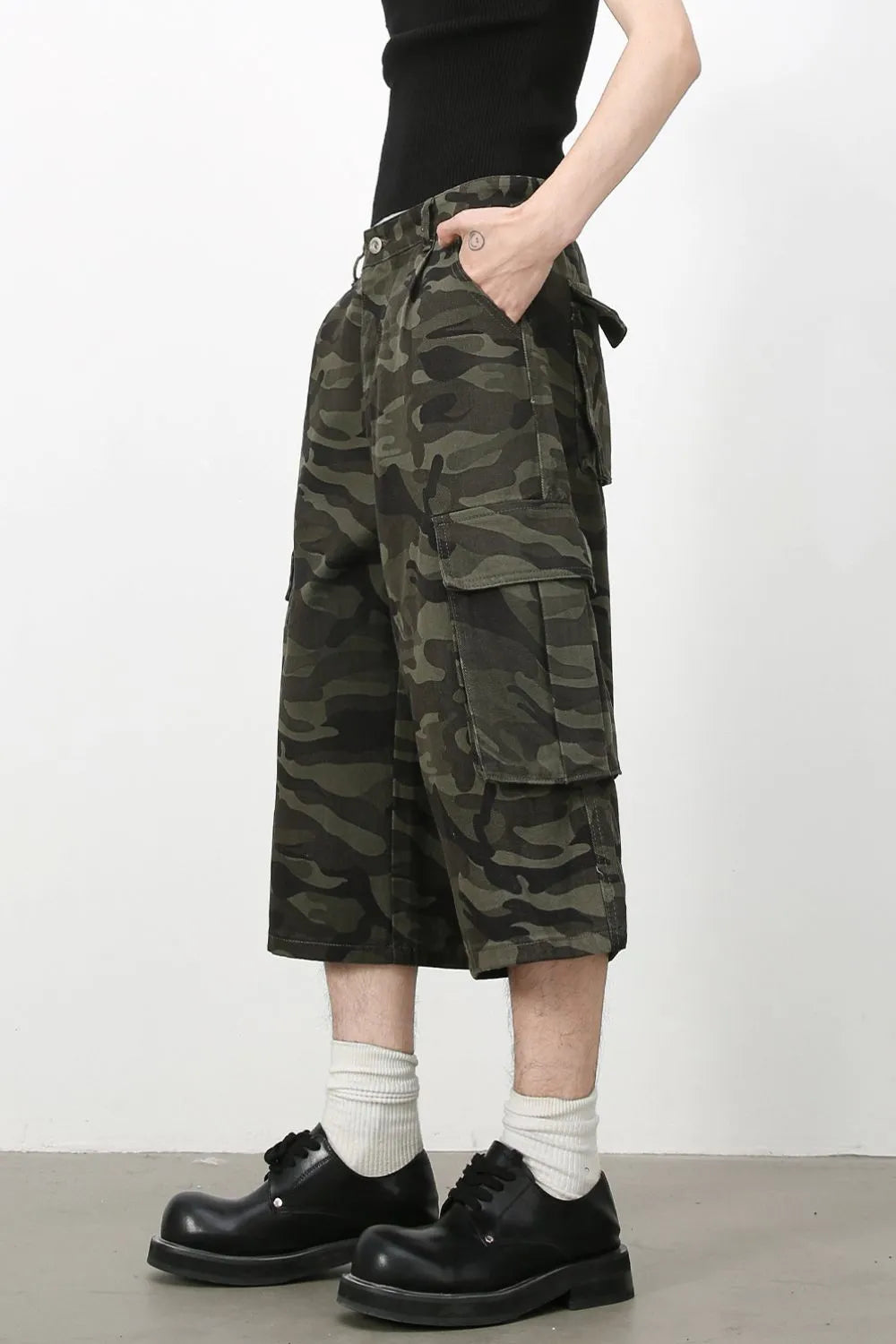 Pleated camo culotte cargo shorts in green camouflage with multiple pockets.