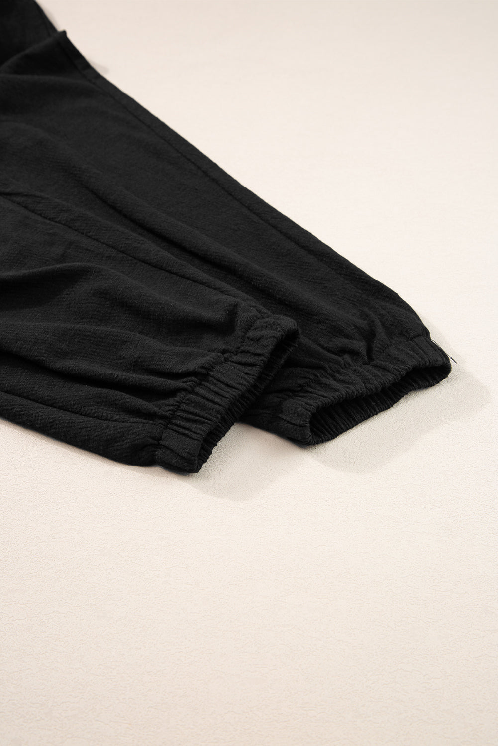 Black textured ribbed waist jumpsuit with elasticated cuffs and drawstring detail