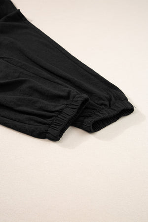 Black textured ribbed waist jumpsuit with elasticated cuffs and drawstring detail