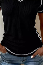 Black waffle knit V-neck tee with contrast white trim on neckline, sleeves, and hem.