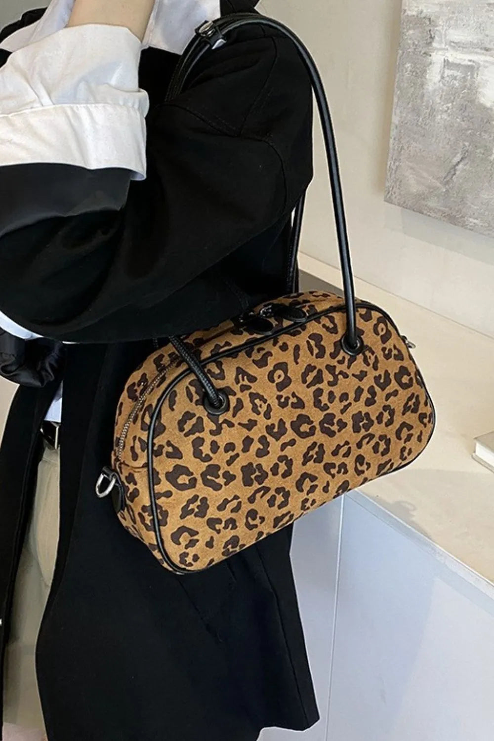 Caramel leopard print barrel bag with black trim and handles