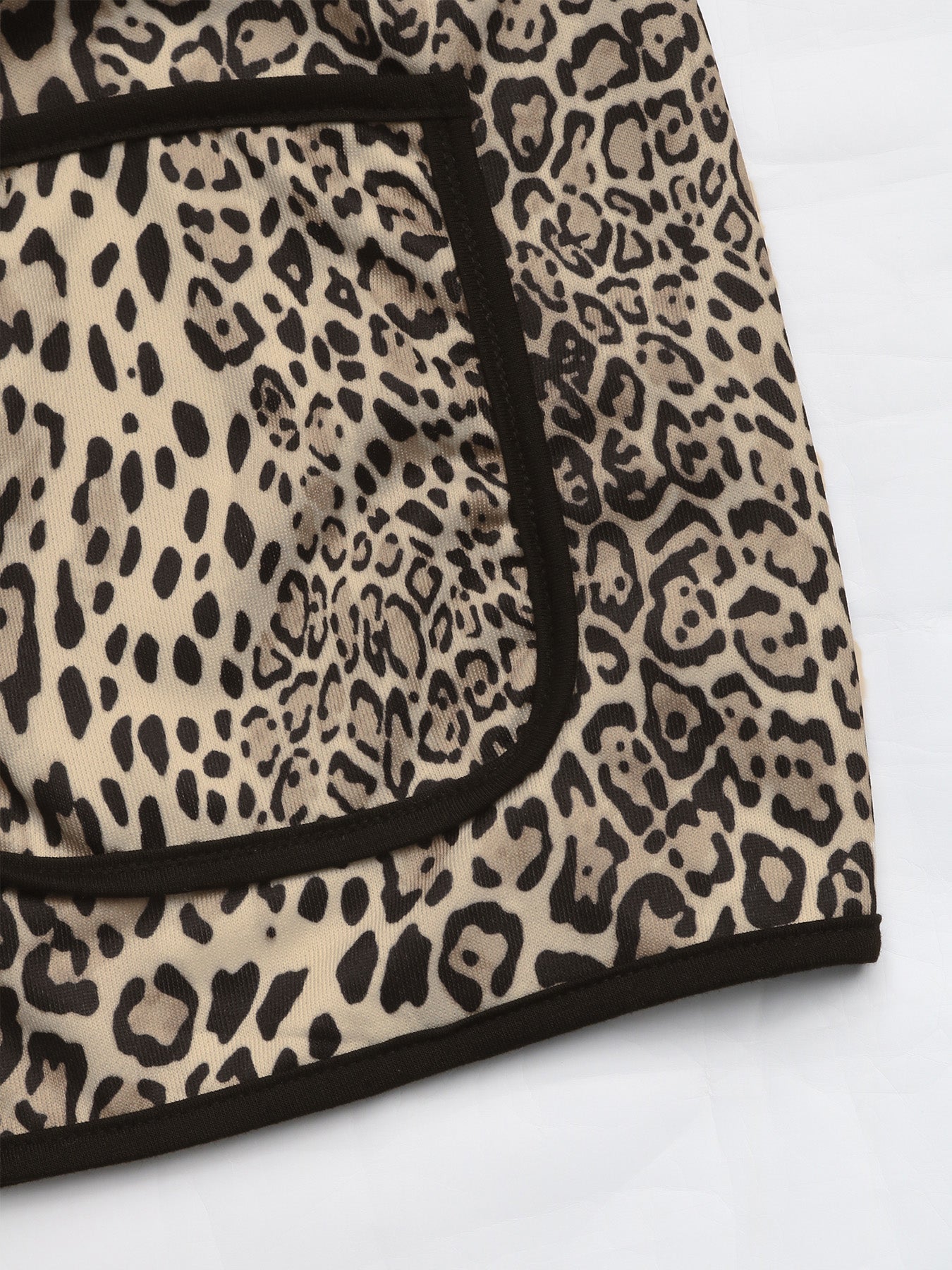 Leopard print boxy jacket with black edge trim and pocket detail.