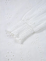 White cotton blouse with eyelet embroidery and smocked cuff detail.