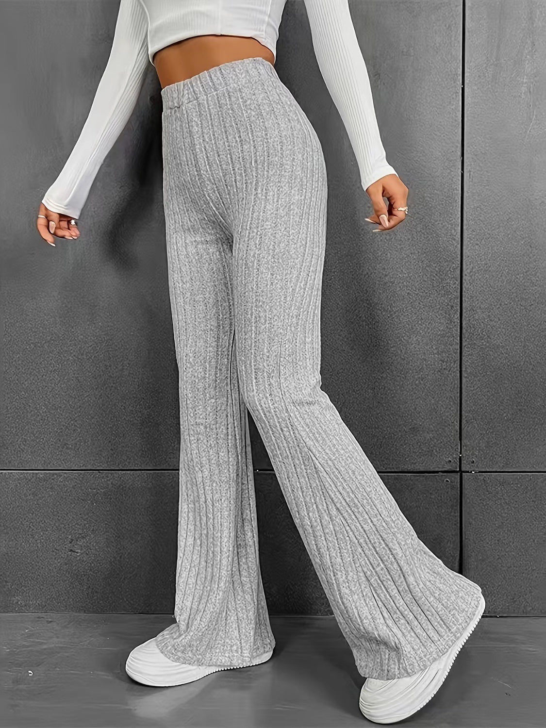 Gray ribbed polyester flare trousers with a high waist and bootcut leg.
